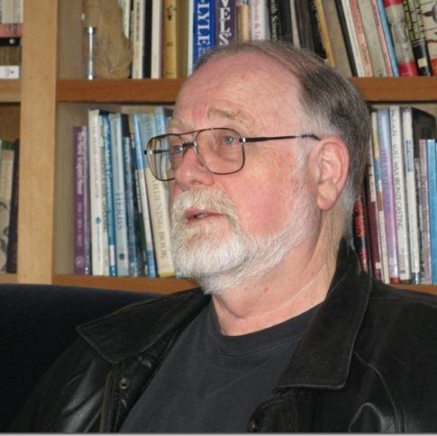 Bill Engleson in front of a bookshelf