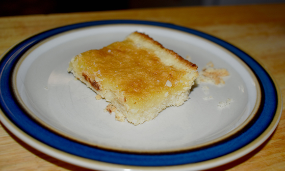 Lemon Bar on a white plate with blue rim